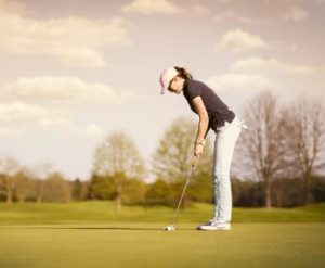 パッティング中の女性ゴルファー